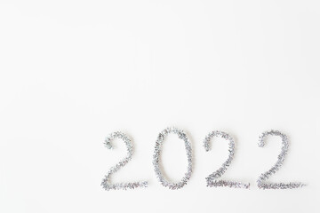 Happy new year 2022 written in foil and new year rain on an isolated white background. Happy new year greetings.
