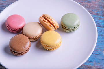 Stacked macarons of different flavors on a plate.