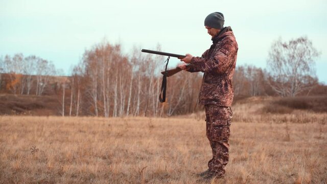 The hunter loads the shotgun on the hunt