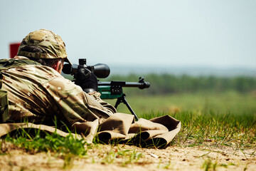 a sniper shoots lying down with a rifle with an optical sight