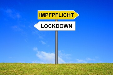 Schild Wegweiser zeigt: Lockdown oder Impfpflicht?