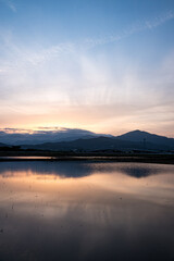 Obraz premium 水面と夕焼け空のリフレクション