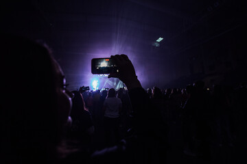 fans are filming the concert on their phone. take pictures of your favorite musicians as a keepsake