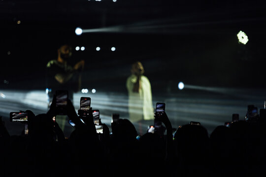 fans are filming the concert on their phone. take pictures of your favorite musicians as a keepsake