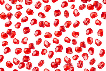 Falling pomegranate seeds isolated on white background.