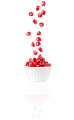 Bowl with pomegranate seeds on an isolated background. Levitation.