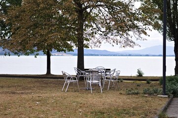 Metal table and chairs in a public park on Lake Trasimeno (Umbria, Italy, Europe) - 470888959