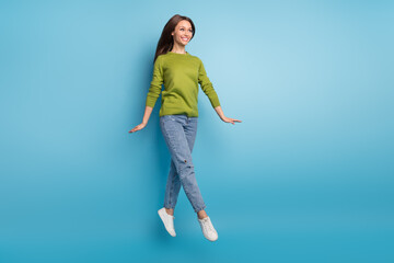 Fototapeta na wymiar Photo of inspired carefree lady dreamy flight enjoy movement wear green shirt jeans isolated blue color background