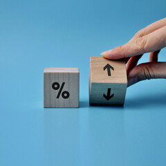Wooden cubes with percentages and up and down arrows. Increase or decrease in interest on profits, loans, or prices