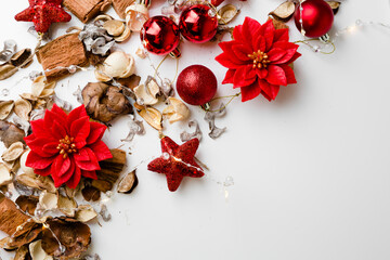 red poinsettia candles with golden flowers and stars and christmas decoration on a white background
