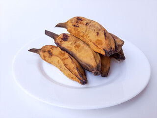 Steamed banana, on a white plate. Isolated in white background