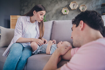Portrait of attractive funky cheerful full family mom dad playing with baby resting cuddling spending time at home indoors