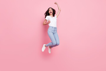 Full size photo of cheerful young positive woman jump up air winner celebrate isolated on pink color background