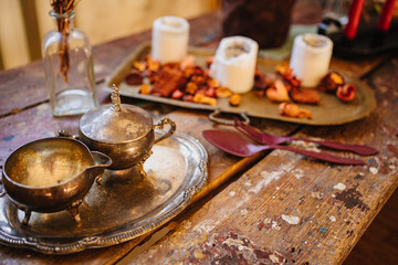 silver tableware, white candles and dried flowers on a tray as retro style decor