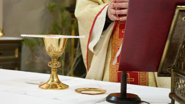 The priest says a prayer over the golden chalice intended for the holy communion after confession.
