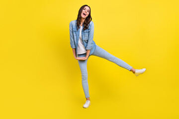 Fototapeta na wymiar Photo of shiny charming young woman dressed denim shirt dancing smiling isolated yellow color background