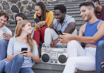 Diverse young people having fun together in the city with vintage music boombox
