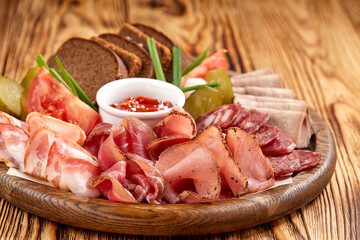 Meat platter with selection on wooden background