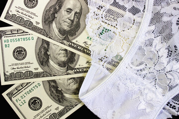 US dollars, condom and women's panties. Intimacy, sex and prostitution