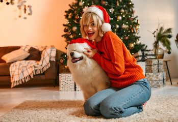 Obraz premium Couple in love for New Year and Christmas with a dog at home