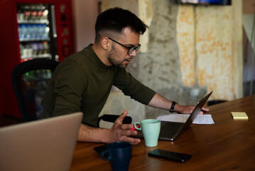 Young businessman working with laptop at office. Businessman sitting at office desk working on laptop computer..
