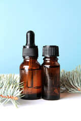 A bottle with cosmetic oil or face serum with pine twigs. Pine essential oil or skin care solution for anti age treatment. Copy space.