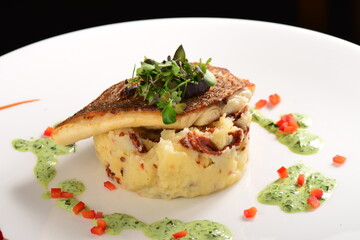 Tasty healthy fish fillet with potato puree with dried tomatoes and wild garlic sauce