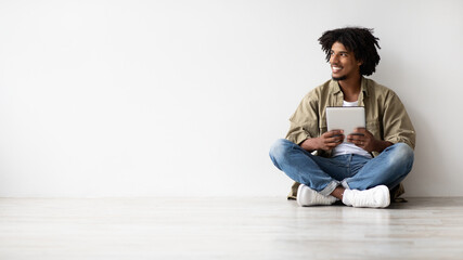 Online Offer. Cheerful Young Black Guy Holding Digital Tablet And Looking Aside