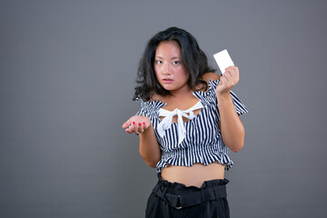 beautiful young chinese woman with card in hand and graceful expression of hesitation