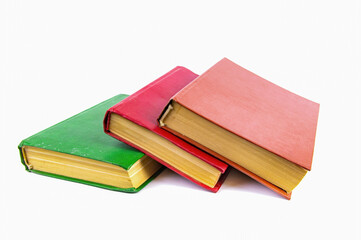 A stack of old books with colored covers. Books for reading. Old book. Book page of yellow paper. White background. Paper product. Read literature. Background picture.