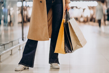 Woman with shopping bags making purchases in mall