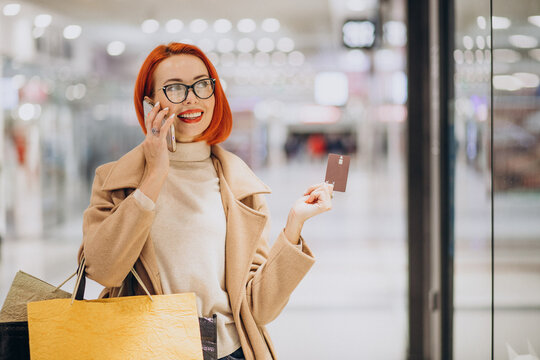 Woman In Shopping Mall Paying With Credit Card