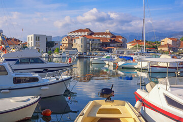 Fototapeta na wymiar Sunny day, beautiful Mediterranean landscape.Fishing boats in harbor. Montenegro, Bay of Kotor. View of Tivat city and marina Kalimanj
