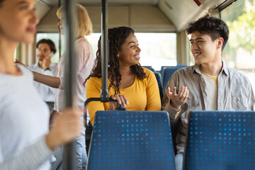 Happy smiling guy and lady taking bus and talking