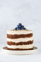 Homemade carrot cake with cream and blueberries. Sugar, gluten, lactose free, vegan, healthy food.