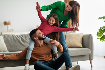 Portrait of happy Arab family playing, having fun at home