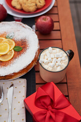 Christmas pie, cocoa with marshmallows and table. Christmas tree background. Van mobile trailer, mobile home, terrace. New Year celebration. Winter holidays. Christmas morning.