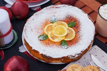 Christmas pie, cocoa with marshmallows and table. Christmas tree background. Van mobile trailer, mobile home, terrace. New Year celebration. Winter holidays. Christmas morning.
