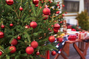 Christmas background live fir tree with red toy balls. New Year celebration. Winter holidays