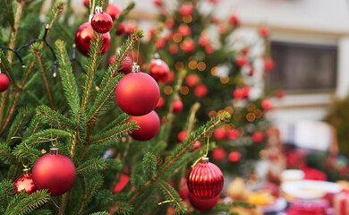 Christmas background live fir tree with red toy balls. New Year celebration. Winter holidays