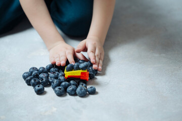 Transportation of fresh juicy blueberries for a customer, a boy plays on the floor in a typewriter. the concept of delivery and supply of healthy food to the population.