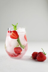Summer cocktail with strawberry  and mint. Refreshing drinks or beverage for summer, cold sweet and sour lemonade in the glasses with sliced fresh strawberry on white background. Refreshing concept
