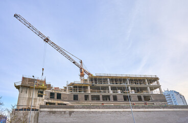 Building crane and new building under construction. Clear sky. High quality photo