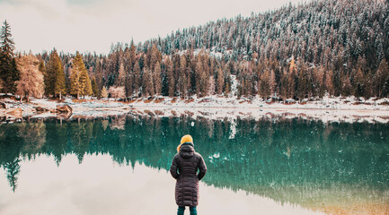 Obraz premium woman watchin amazing turquoise water of Caumasee in winter Switzerland slow travel