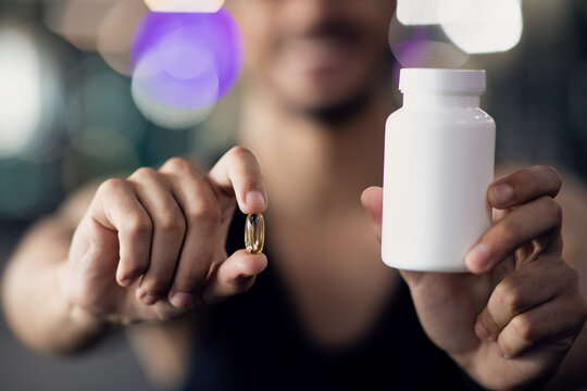 Sports Multivitamins. Athlete Man Holding Blank Jar And Supplement Capsule Pill
