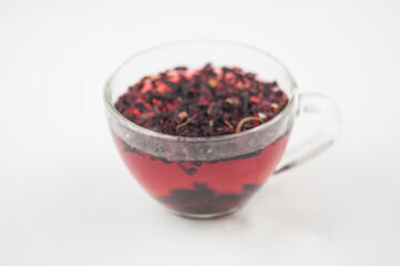 Obraz na płótnie Canvas Karkade. Tea drink in a glass. Red liquid in a glass. Dried petals. Hibiscus. Sudanese rose