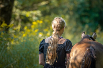 Mädchen geht mit jungem Pferd spazieren