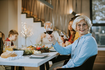 Happy family having a dinner with red wine at home