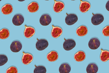 Pattern of fresh ripe whole and sliced figs on blue background. Creative food concept.
