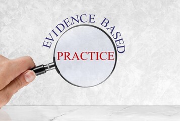 Phrase evidence based practice with a person's hand hold magnifying glass.
